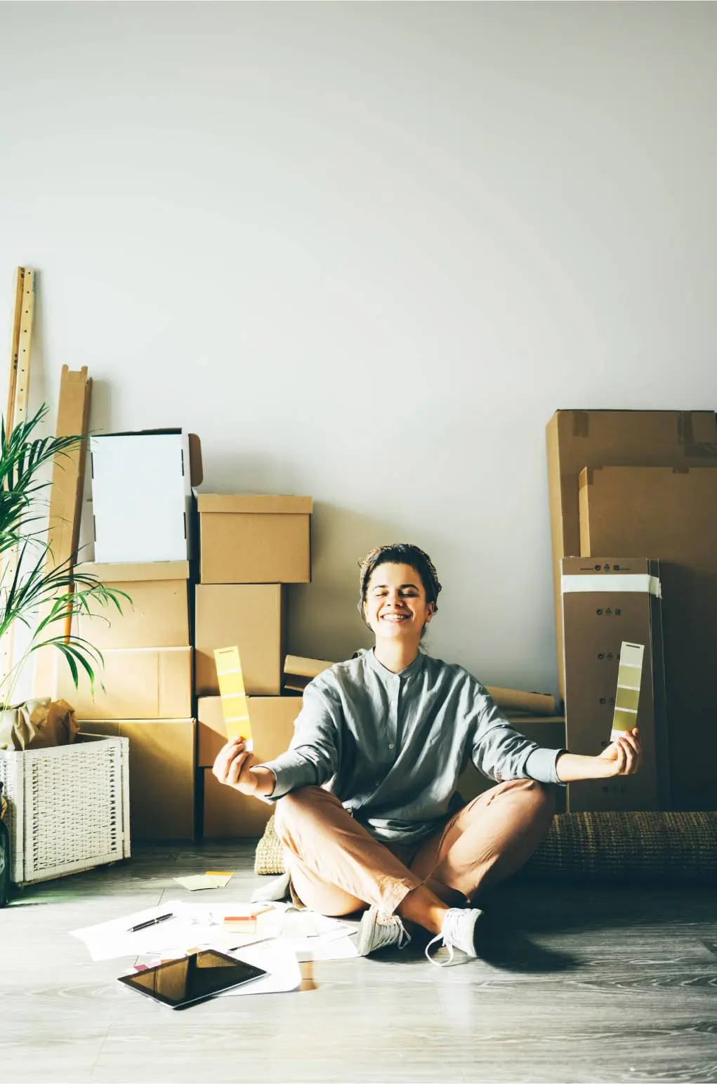 Person sitting on the floor with cardboard boxes and papers