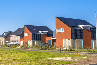Residential street with modern brick houses under blue sky