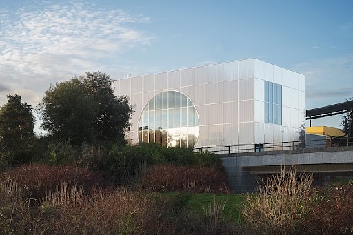 Modern building with circular window and surrounding greenery